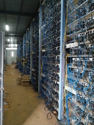 An aerial view of a large-scale Bitcoin mining farm, showcasing rows of shipping containers filled with mining rigs.